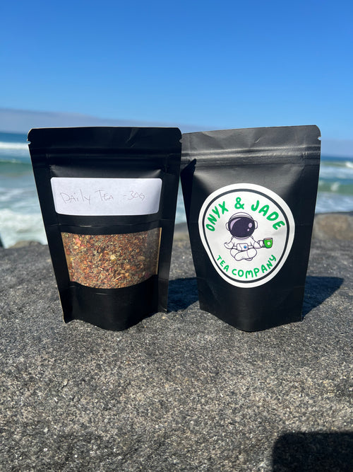 Front and back of the Onyx & Jade Tea Company Daily Tea package showing the product label, ingredient information, preparation directions, and package details