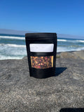Onyx & Jade Tea Company Glow Tea pouch, featuring a caffeine free hibiscus and citrus blend with rosehips, honeybush, orange, lemon, rose, ginger, and lemongrass.
